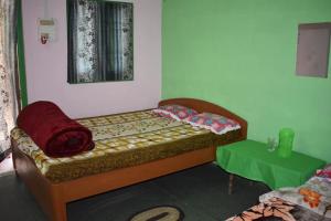 Jyoti GaonMANAS RAY HOMESTAY的一间卧室配有一张床和一张绿桌
