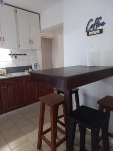 内乌肯Casa Luz的厨房配有一张大木桌和凳子