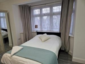 WansteadElegant 2-Bedroom Double En-Suite Flat - London的卧室配有白色的床和窗户。