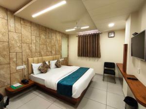 艾哈迈达巴德Hotel Kinara的配有一张床和一台平面电视的酒店客房