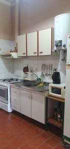 拉里奥哈Nuestro Quincho的厨房配有白色橱柜和炉灶烤箱。