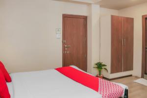 浦那Super Collection O Hotel Pearl Near Shaniwar Wada的一间卧室配有一张床铺,床上铺有红色毯子