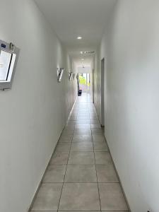 圣洛伦索Plaza Km 325的走廊设有白色墙壁和瓷砖地板