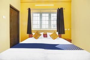哥印拜陀SPOT ON Kayal Residency的一间卧室设有一张大床和窗户
