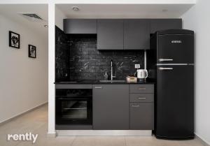 埃拉特Sea side "Marigold" apartment - by Rently的厨房配有黑色家电和黑色冰箱。
