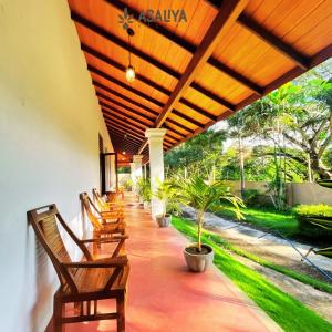 AswalapitiyaAsaliya Villa的一个带椅子和植物的有盖门廊