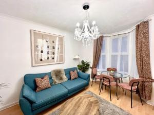 剑桥Central Cambridge Fig Tree House Flat 1的客厅配有蓝色的沙发和玻璃桌