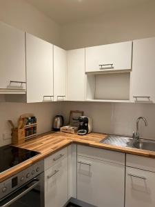 巴特罗森菲尔德BRAN: Design - Apartment Küche, Parken ,Netflix的厨房配有白色橱柜和水槽