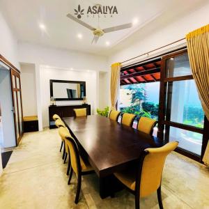 AswalapitiyaAsaliya Villa的一间带木桌和黄色椅子的用餐室