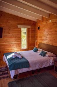 巴拉斯港Tiny House con opción de tina temperada的木制客房内的一间卧室配有一张大床
