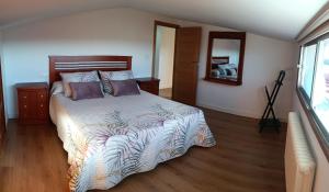 坎巴多斯ATICO B&P CAMBADOS的一间卧室设有一张大床,铺有木地板