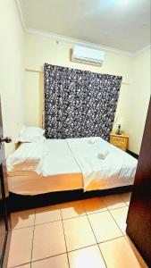 哥打京那巴鲁Ber-Santai at Marina Court的一间卧室配有床和窗帘
