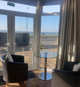 索伦特海峡旁利村The Waters Edge的客厅配有两把椅子和一张玻璃桌