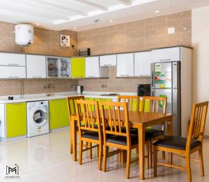 塔伊夫منتجع الكناري للفلل الفندقية الفاخرة Canary resort的厨房配有桌椅和冰箱。