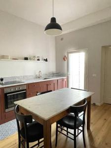 蓬泰代拉Appartamento con terrazza e parcheggio privato的厨房配有大型木桌和椅子