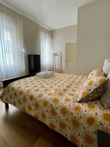 蓬泰代拉Appartamento con terrazza e parcheggio privato的一间卧室配有一张黄色和白色花卉的大床