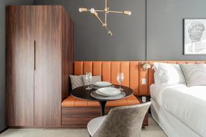 圣保罗Iconyc Charlie Hotel São Paulo - Soft Opening的一间卧室配有桌子、床和桌椅