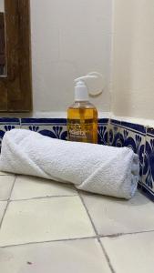 瓦哈卡市Posada Regional的浴室楼层提供毛巾和1瓶肥皂