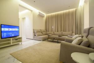 利雅德شقة انيقة وفاخرة بحي العليا Elegant and luxurious apartment Al-Olaya的带沙发和平面电视的客厅