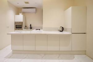 利雅德شقة انيقة وفاخرة بحي العليا Elegant and luxurious apartment Al-Olaya的白色的厨房配有水槽和冰箱