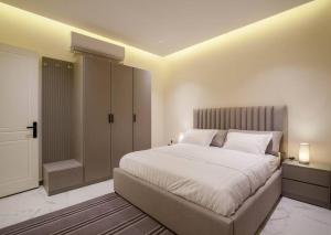 利雅德شقة انيقة وفاخرة بحي العليا Elegant and luxurious apartment Al-Olaya的卧室配有一张白色大床和一个衣柜