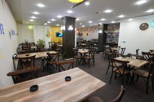 埃尔比勒Soulmate Hotel Erbil的一间设有木桌和椅子的餐厅