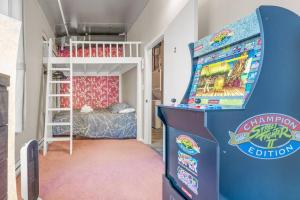 埃德蒙顿Chic 2-Bedroom Apt With Arcade的客房设有弹球机和双层床。