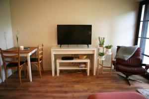 Blainroe Cottage的客厅配有电视和桌椅