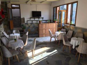 吉诺卡斯特Hostel Mateo的餐厅设有白色的桌椅和电视。