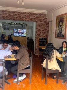 库斯科Cusco House Inn Hostel的一群坐在餐厅桌子上的人