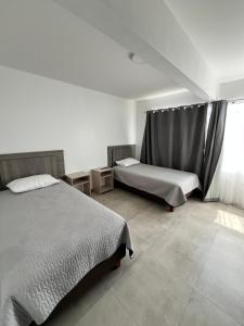伊基克Hotel Santa María的一间卧室设有两张床和窗户。