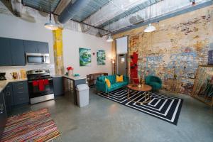 孟菲斯Cozy Luxurious Loft in Downtown Memphis的厨房以及带沙发和桌子的客厅。