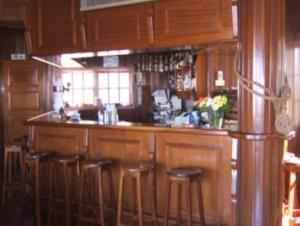 卡尼索维拉文图拉酒店的厨房配有木制橱柜和酒吧凳子