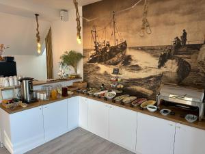 库瑞尼卡慕斯卡DALBA pokoje przy samej plaży的厨房墙上挂有船只壁画
