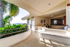 阿卡普尔科Preciosa Villa en Marina Las Brisas的一间带白色沙发的客厅和一间厨房