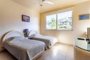 阿卡普尔科Preciosa Villa en Marina Las Brisas的一间卧室设有两张床和窗户。