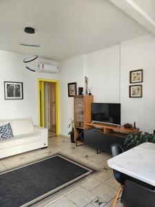 桑托斯Apartamentos na Praia do Gonzaga的客厅配有白色沙发和电视