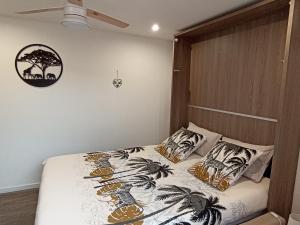 艾吉纳" LE CHABASSOLE " CHAMBRES D'HÔTES - Massages - Jacuzzi - Sauna - GORGES DU VERDON的一间卧室配有一张带木制床头板和枕头的床。