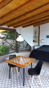 吉亚迪诺镇Cabaña La Emilia - Villa Giardino的配有桌子和两把椅子及一张床的房间