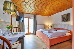 奥巴拉马高Gästehaus Eder Oberammergau的一间卧室配有一张床铺和一张桌子,还有一间用餐室