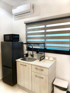 阿比让Appartement Palms Abidjan的厨房配有水槽和黑冰箱。