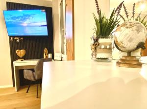 克拉根福BaMo Studio - city living arkaden的客房设有带球盘的桌子和电视