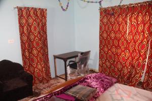 斯利那加Baba BabaBah的一间设有红色和金色窗帘和桌子的房间