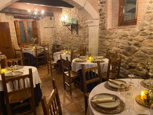 莱德斯马La Clerecia de Ledesma的餐厅设有白色的桌椅和蜡烛