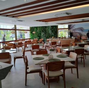 伊波茹卡Flat com vista para piscina principal的餐厅内带桌椅的用餐室