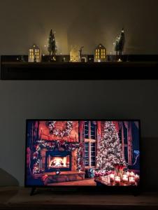 布尔泽策BratSki Apartman - 200m od gondole的房间里的电视机上放着圣诞树