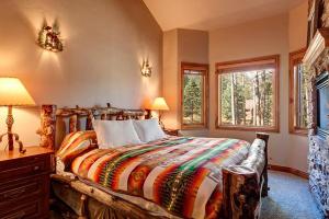 布雷肯里奇Four Pines Retreat的一间卧室配有一张大床和色彩缤纷的毯子