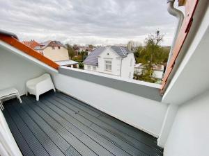 代特莫尔德Cute Apartment - Detmold city center - large kitchen, bath, south facing balcony - free parking and wifi的阳台享有白色房屋的景致。