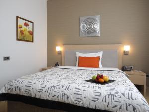 贝尔格莱德IN贝尔格莱德酒店的一间卧室配有一张床,上面有水果盘