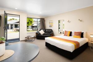 布伦海姆中心球场汽车旅馆的一间卧室配有一张特大号床和一张沙发